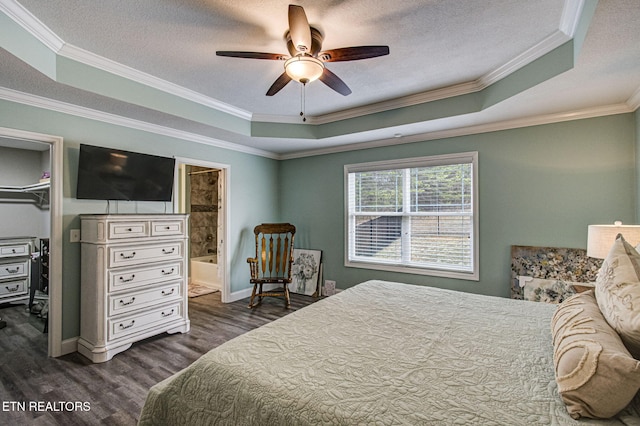 bedroom with a tray ceiling, a spacious closet, a textured ceiling, and dark hardwood / wood-style floors