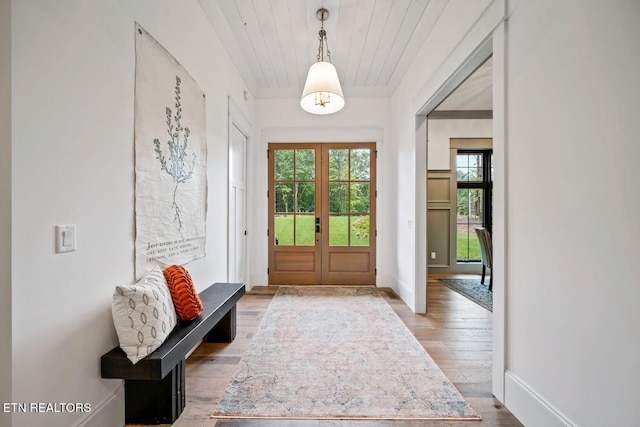 foyer with hardwood / wood-style floors, plenty of natural light, and french doors