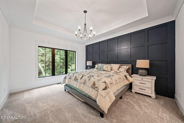 carpeted bedroom with crown molding, a chandelier, and a tray ceiling