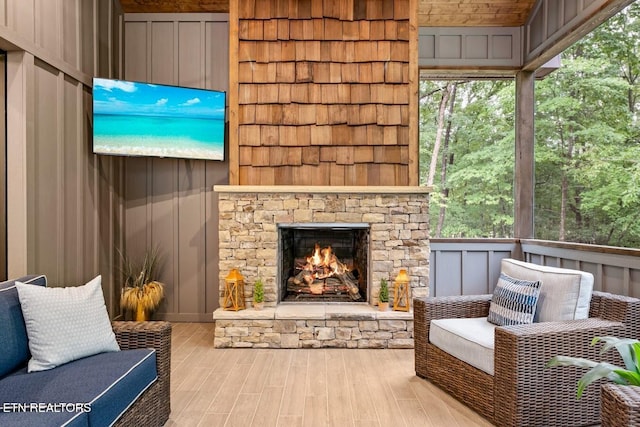 exterior space featuring a healthy amount of sunlight, a stone fireplace, and light hardwood / wood-style flooring