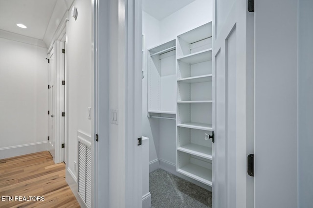 walk in closet with hardwood / wood-style floors