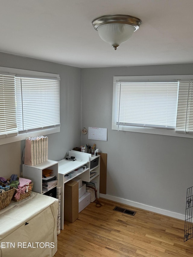 home office featuring light wood-style floors, baseboards, and visible vents