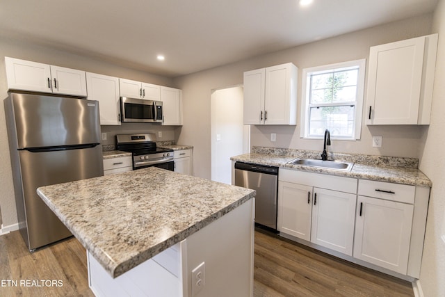 kitchen featuring a kitchen island, white cabinetry, appliances with stainless steel finishes, and sink