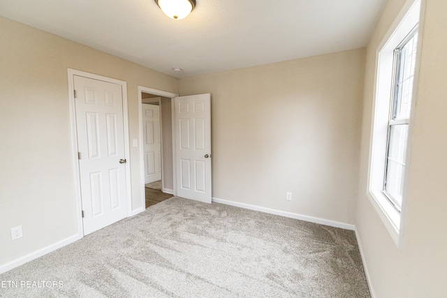 unfurnished bedroom with multiple windows and carpet