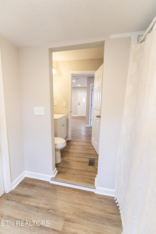 bathroom with hardwood / wood-style floors and a textured ceiling