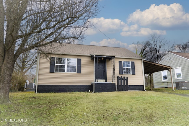 view of front of home featuring a carport, a front yard, and cooling unit