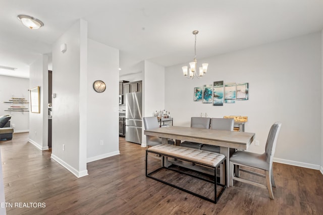 dining space featuring dark wood-style floors, visible vents, a notable chandelier, and baseboards