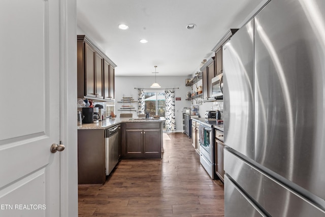 kitchen featuring dark wood-style flooring, recessed lighting, hanging light fixtures, appliances with stainless steel finishes, and light stone countertops