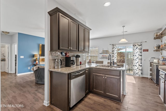 kitchen with dark wood-style flooring, stainless steel dishwasher, dark brown cabinetry, a sink, and a peninsula