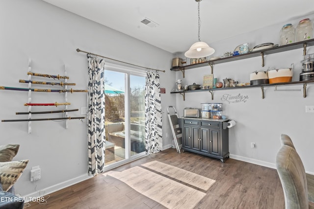 dining space featuring visible vents, baseboards, and wood finished floors