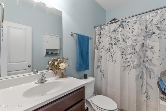 full bathroom featuring toilet, curtained shower, and vanity