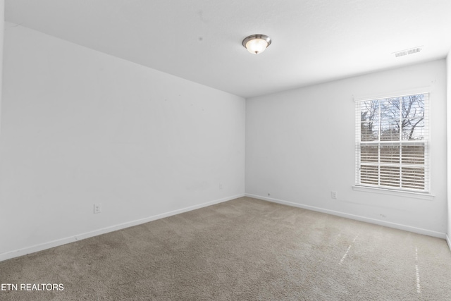 carpeted empty room featuring visible vents and baseboards