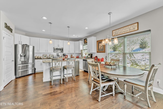 dining space featuring baseboards, dark wood-type flooring, and recessed lighting