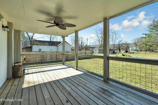 wooden deck with ceiling fan and a lawn