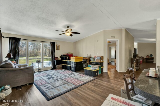 living room featuring ornamental molding, dark wood-type flooring, ceiling fan, and a textured ceiling