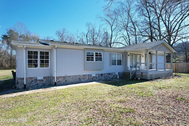 ranch-style home featuring covered porch and a front lawn