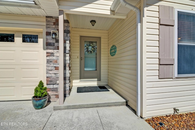 doorway to property featuring a garage and stone siding