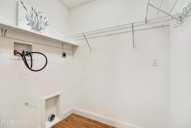 clothes washing area with laundry area, washer hookup, baseboards, light wood finished floors, and electric dryer hookup