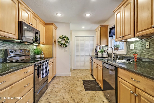 kitchen featuring dark stone countertops, a sink, decorative backsplash, and black appliances