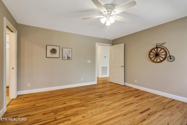 unfurnished room with light wood-style floors, visible vents, and baseboards