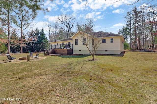 view of side of property featuring an outdoor fire pit, a lawn, crawl space, stairs, and a deck