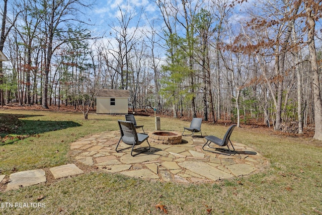 view of yard featuring a storage shed, an outdoor fire pit, an outbuilding, and a patio