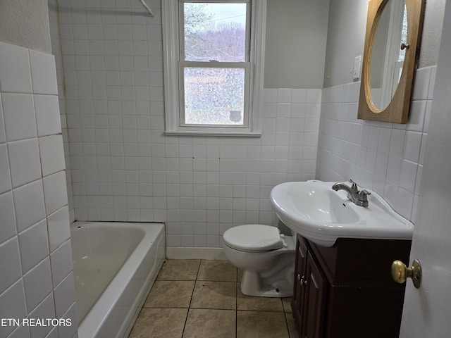 bathroom with toilet, tile patterned floors, tile walls, and vanity