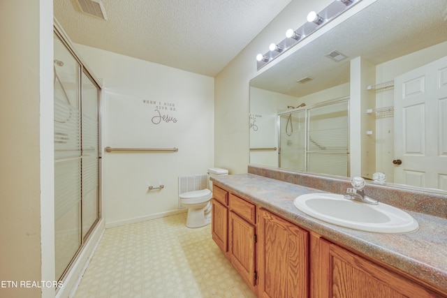 bathroom featuring a stall shower, visible vents, vanity, and a textured ceiling