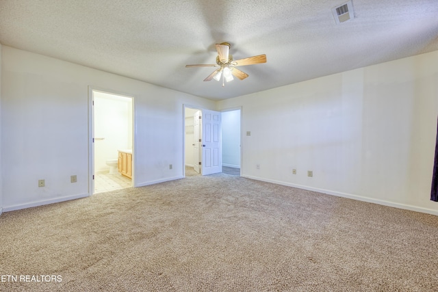 spare room with a textured ceiling, baseboards, a ceiling fan, and light colored carpet