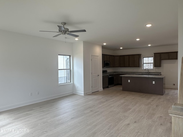 kitchen with sink, light hardwood / wood-style flooring, ceiling fan, range, and a kitchen island