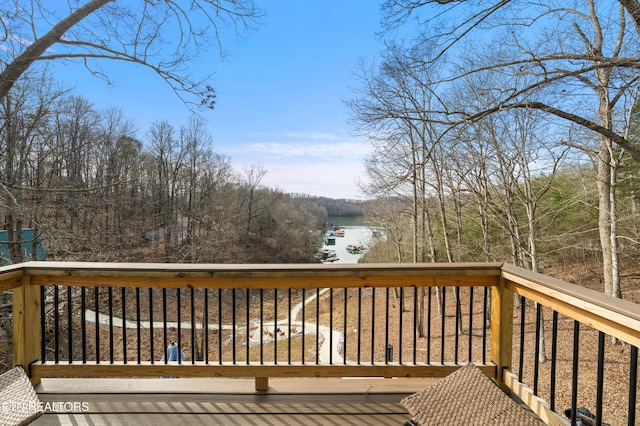 wooden deck featuring a water view and a wooded view