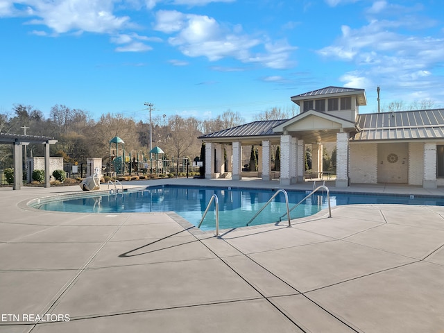 community pool with fence and a patio area