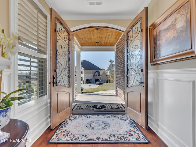 foyer with visible vents, arched walkways, wood ceiling, and dark wood finished floors