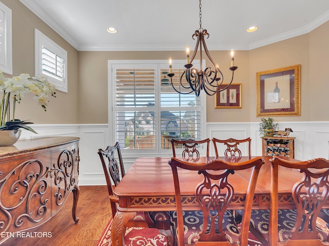 dining space with recessed lighting, wood finished floors, a wainscoted wall, and ornamental molding