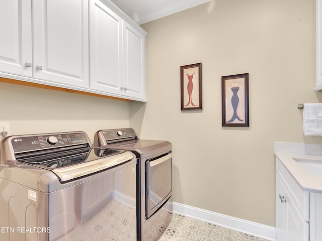 laundry area featuring baseboards, cabinet space, crown molding, and washing machine and clothes dryer