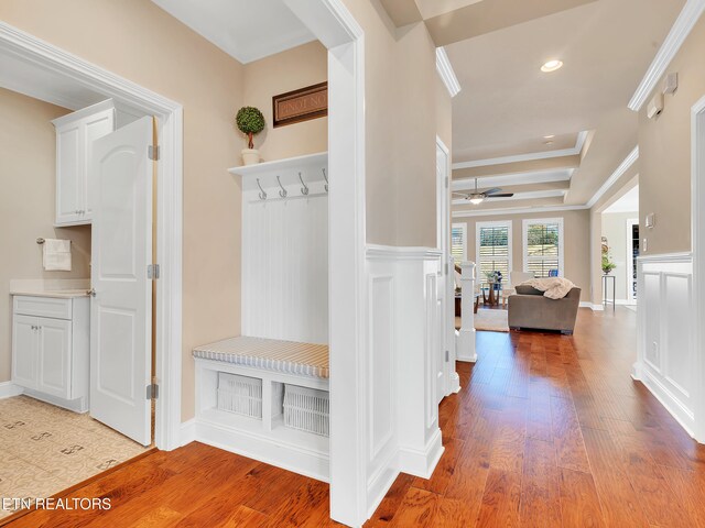 mudroom featuring hardwood / wood-style floors, a wainscoted wall, ornamental molding, and a decorative wall