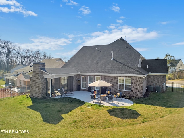 rear view of property with a patio area, brick siding, a fenced backyard, and a lawn