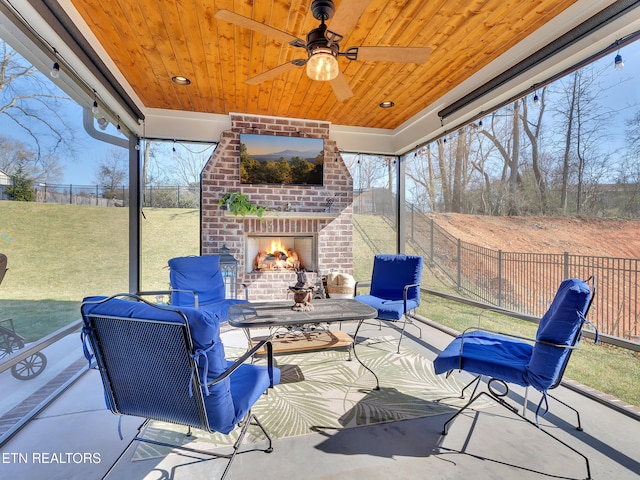 view of patio / terrace featuring ceiling fan, an outdoor brick fireplace, and fence