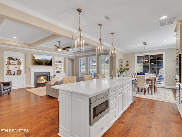 kitchen with a glass covered fireplace, visible vents, stainless steel appliances, and a sink