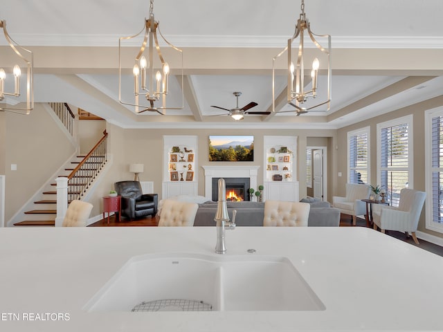 dining room with stairway, built in features, ornamental molding, a warm lit fireplace, and wood finished floors