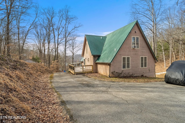 view of home's exterior featuring metal roof and a wooden deck