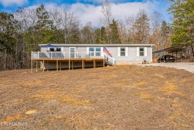 view of front of property featuring driveway, a deck, and a detached carport