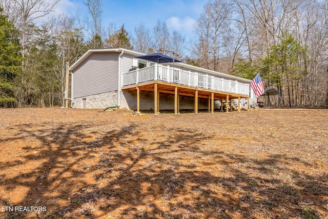 rear view of property featuring crawl space and a wooden deck