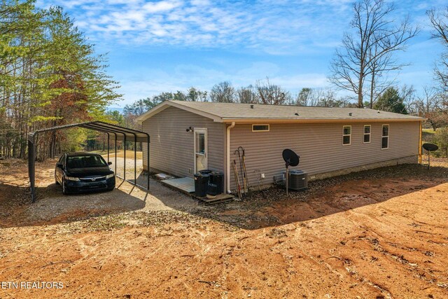 back of property featuring a carport and cooling unit