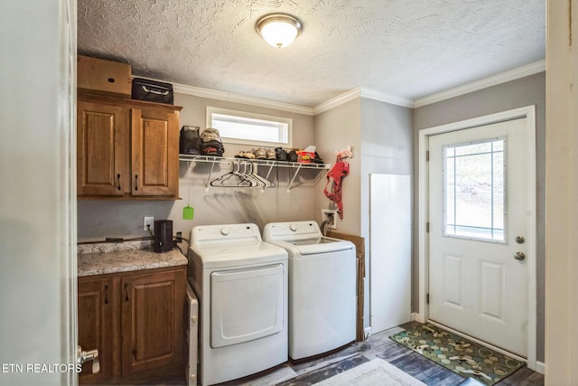 clothes washing area featuring crown molding, washer and dryer, cabinet space, and plenty of natural light