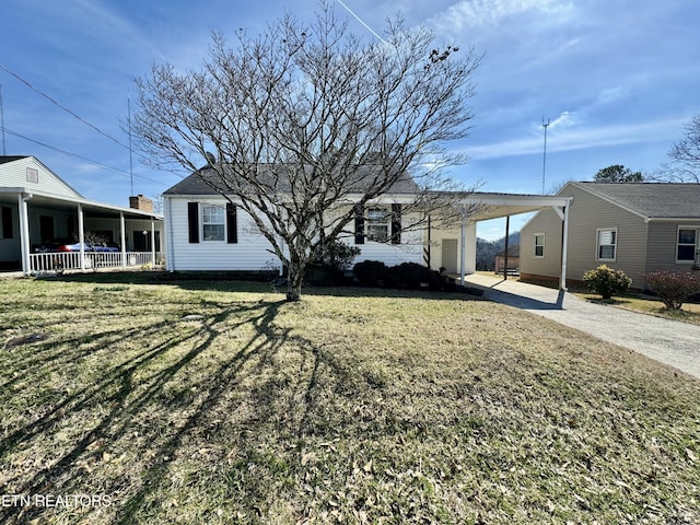 exterior space with a carport, covered porch, and a front lawn