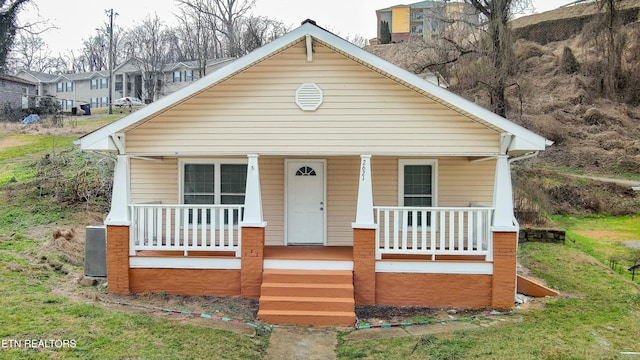 bungalow-style house with a porch and central AC