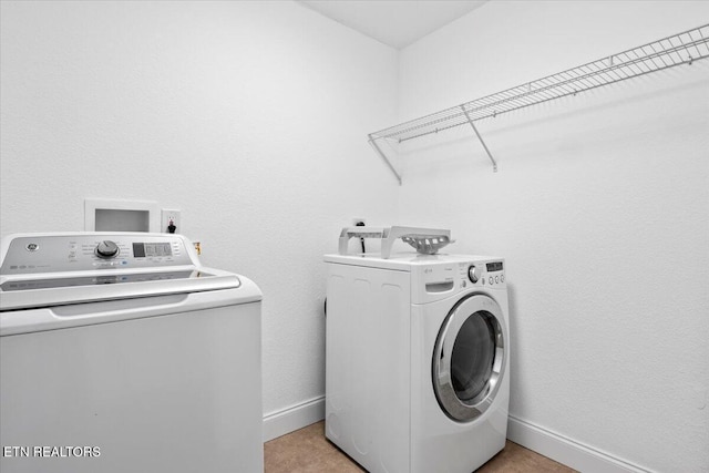 laundry area with laundry area, baseboards, and independent washer and dryer