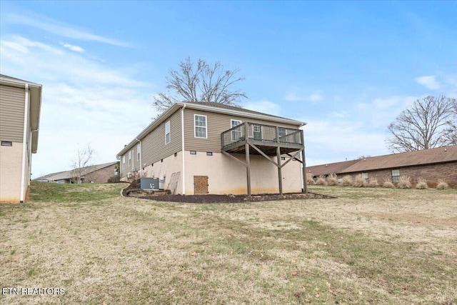 rear view of house featuring a yard, central AC unit, and a wooden deck