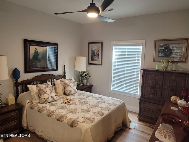 bedroom featuring light wood finished floors, ceiling fan, and visible vents